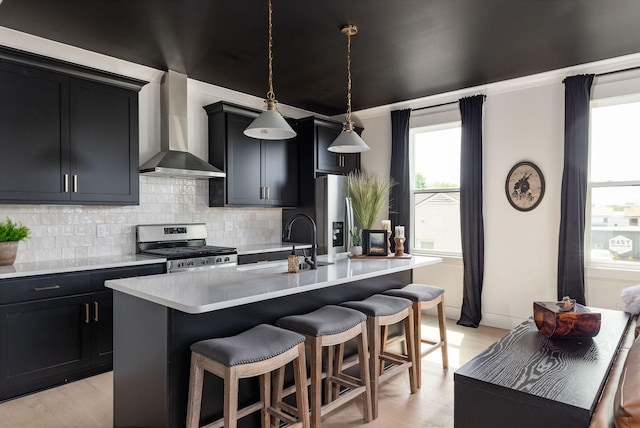 326A E Trinity Ln, Nashville, TN 37207 - kitchen featuring wall chimney exhaust hood, appliances with stainless steel finishes, a sink, dark cabinets, and an island with sink