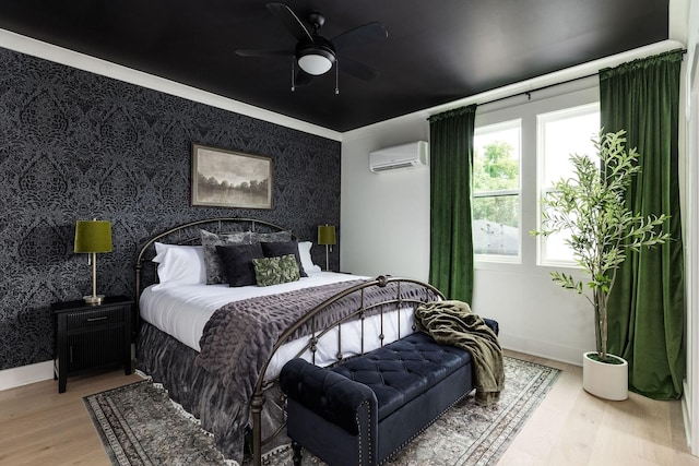 326A E Trinity Ln, Nashville, TN 37207 - bedroom featuring a wall mounted AC, wood finished floors, wallpapered walls, an accent wall, and baseboards