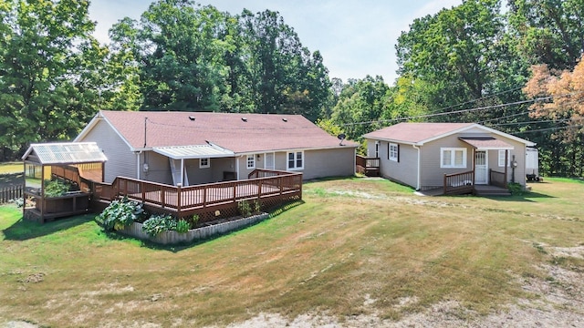 7464 Harrington Pl, Lyles, TN 37098 - rear view of house with a wooden deck, a greenhouse, a lawn, and an outbuilding