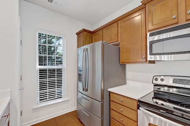 347 Blockade Ln, Mount Juliet, TN 37122 - kitchen featuring stainless steel appliances, light countertops, wood finished floors, and brown cabinets