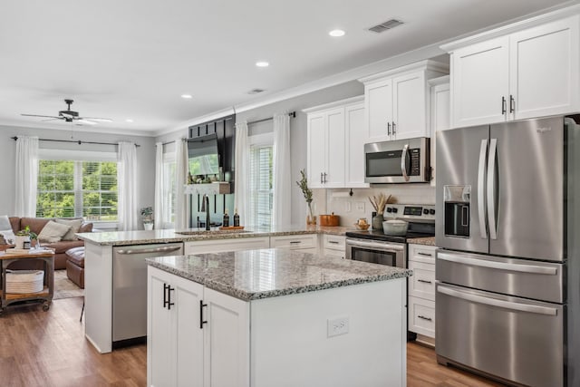 8035 Auburntown Rd, Auburntown, TN 37016 - kitchen featuring stainless steel appliances, a peninsula, crown molding, open floor plan, and a kitchen island