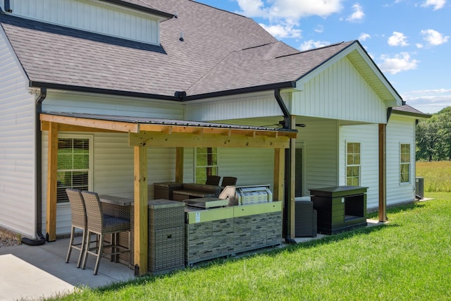 8035 Auburntown Rd, Auburntown, TN 37016 - back of property featuring a shingled roof, a patio area, a lawn, and an outdoor kitchen