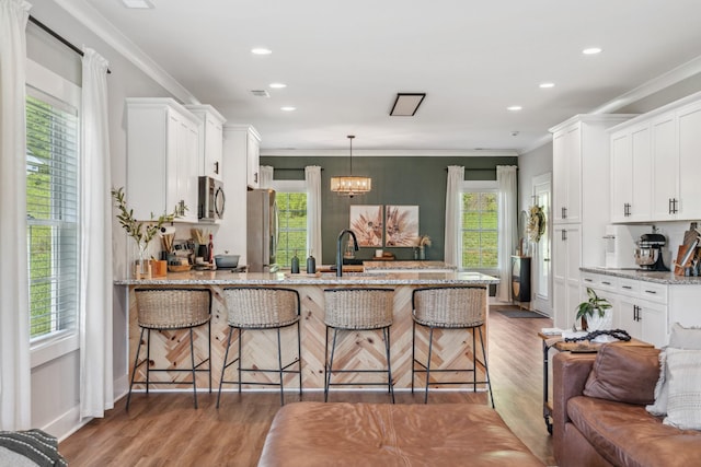 8035 Auburntown Rd, Auburntown, TN 37016 - kitchen with appliances with stainless steel finishes, a peninsula, light wood-style flooring, white cabinetry, and light stone countertops