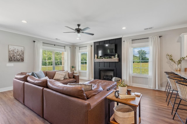 8035 Auburntown Rd, Auburntown, TN 37016 - living room featuring wood finished floors, ceiling fan, a large fireplace, ornamental molding, and baseboards