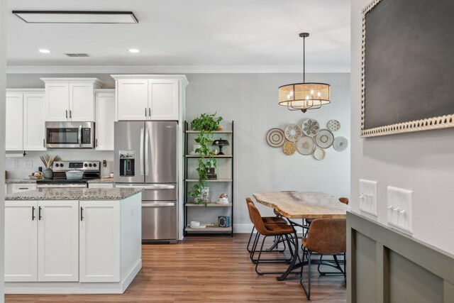 8035 Auburntown Rd, Auburntown, TN 37016 - kitchen with stainless steel appliances, crown molding, white cabinets, light stone counters, and wood finished floors
