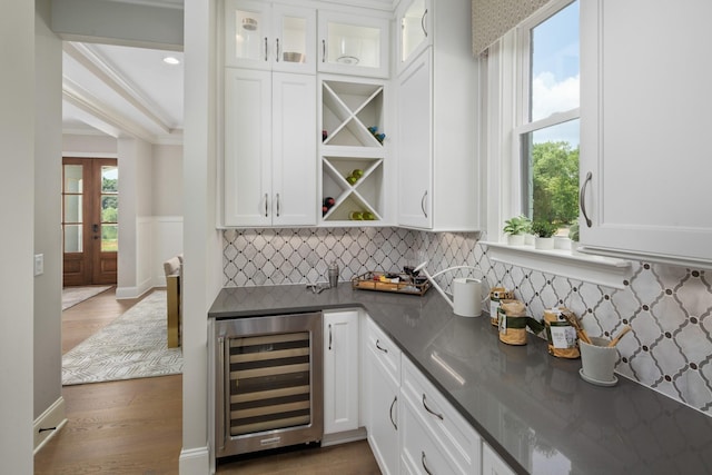7243 Murrel Dr, Franklin, TN 37064 - indoor dry bar featuring beverage cooler, ornamental molding, tasteful backsplash, wood finished floors, and french doors