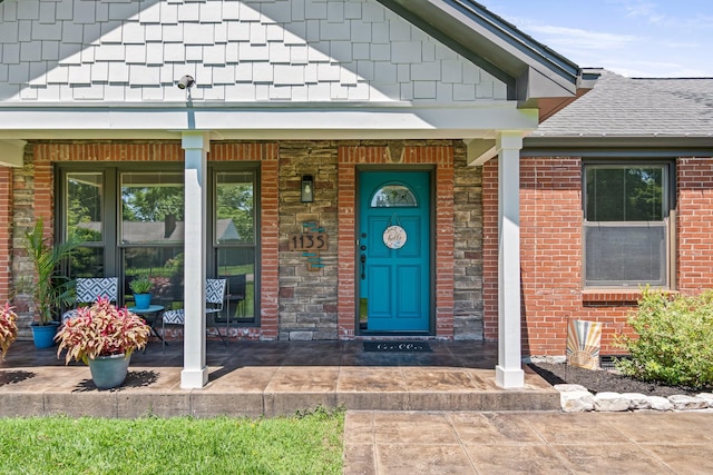 1135 Riverwood Dr, Nashville, TN 37216 - view of exterior entry featuring roof with shingles, brick siding, and a porch