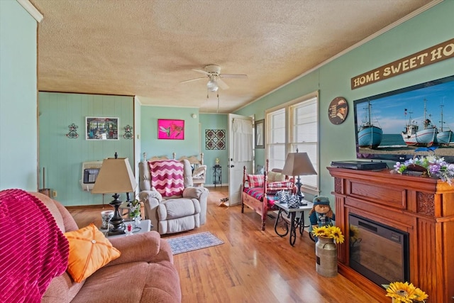410 Sinking Creek Rd, Petersburg, TN 37144 - living area featuring a textured ceiling, ornamental molding, a ceiling fan, a glass covered fireplace, and wood finished floors