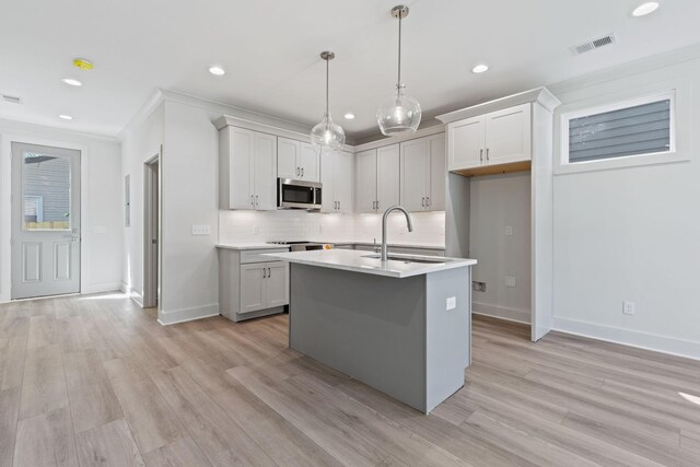 5509 Urbandale Ave, Nashville, TN 37209 - kitchen featuring stainless steel microwave, light wood finished floors, baseboards, backsplash, and a sink