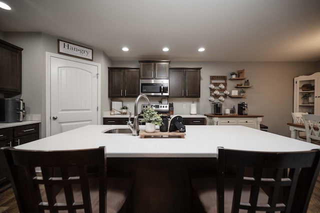 4526 Culpepper Cir, Murfreesboro, TN 37129 - kitchen with stainless steel microwave, dark wood-style flooring, dark brown cabinetry, recessed lighting, and light countertops