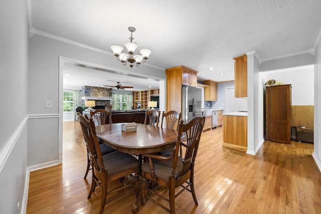 346 Lynnford Dr, Murfreesboro, TN 37128 - dining area with a chandelier, light wood-style flooring, ornamental molding, a stone fireplace, and baseboards