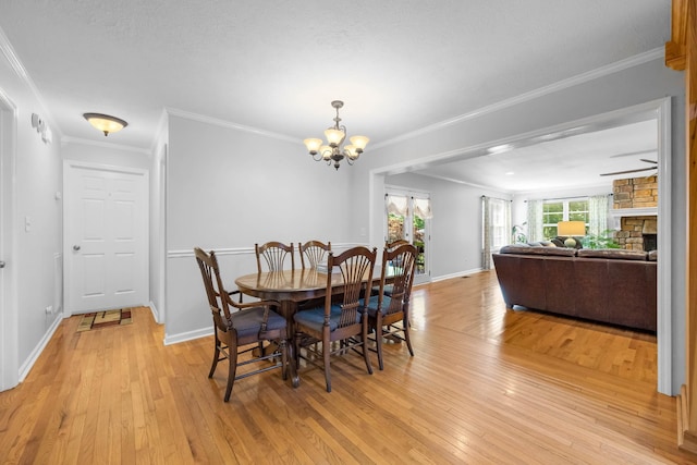 346 Lynnford Dr, Murfreesboro, TN 37128 - dining area featuring light wood-style floors, a chandelier, a fireplace, crown molding, and baseboards