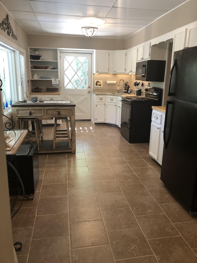 470 Askin Ln, Baxter, TN 38544 - kitchen with black appliances, dark tile patterned flooring, light countertops, white cabinets, and a sink