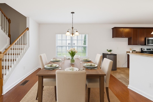3511 Blaze Dr, Murfreesboro, TN 37128 - dining space with stairs, wood finished floors, a chandelier, and baseboards