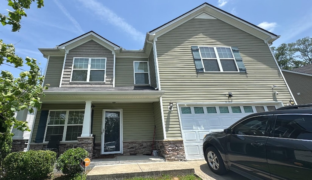 1225 Silverstream Pt, Antioch, TN 37013 - view of front of home with a porch, an attached garage, and stone siding