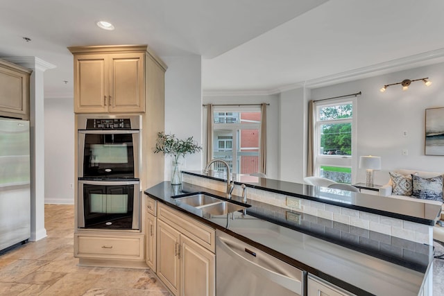 110 31st Ave N Unit 301, Nashville, TN 37203 - kitchen featuring stainless steel appliances, a sink, dark countertops, crown molding, and light brown cabinetry