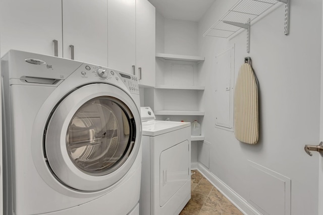 110 31st Ave N Unit 301, Nashville, TN 37203 - washroom featuring cabinet space, stone tile floors, separate washer and dryer, and baseboards