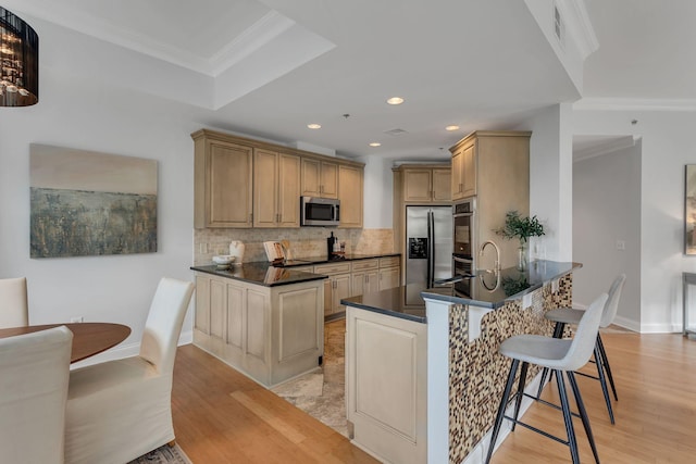 110 31st Ave N Unit 301, Nashville, TN 37203 - kitchen with appliances with stainless steel finishes, crown molding, dark countertops, a peninsula, and decorative backsplash
