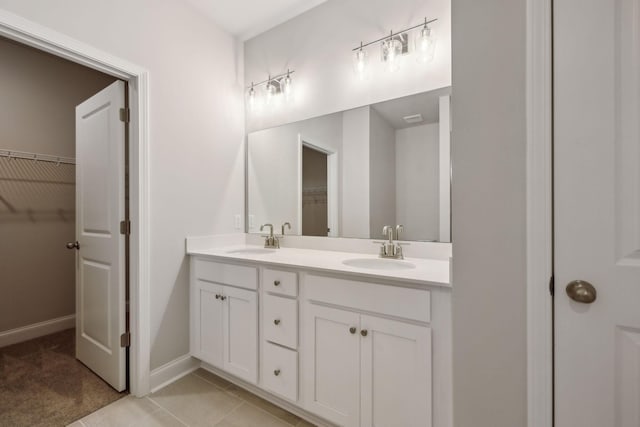 126 Cades Blf, Lebanon, TN 37087 - bathroom featuring double vanity, a walk in closet, baseboards, and tile patterned flooring