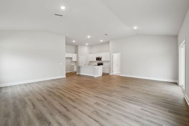 126 Cades Blf, Lebanon, TN 37087 - unfurnished living room with vaulted ceiling, baseboards, recessed lighting, and light wood-type flooring