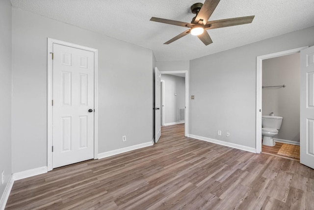 337 Atlantic Ave, Oak Grove, KY 42262 - unfurnished bedroom with wood finished floors, a textured ceiling, ensuite bathroom, baseboards, and ceiling fan
