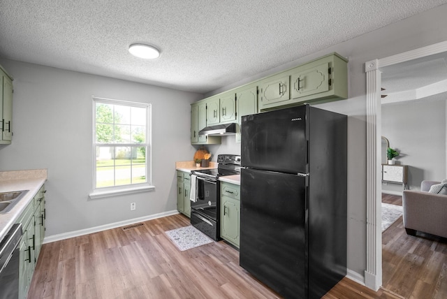 337 Atlantic Ave, Oak Grove, KY 42262 - kitchen featuring green cabinets, black appliances, under cabinet range hood, light wood finished floors, and light countertops