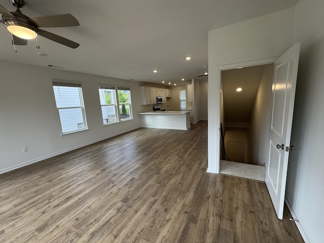 410 Blair Rd, Smyrna, TN 37167 - unfurnished living room featuring wood finished floors, recessed lighting, a ceiling fan, baseboards, and a sink