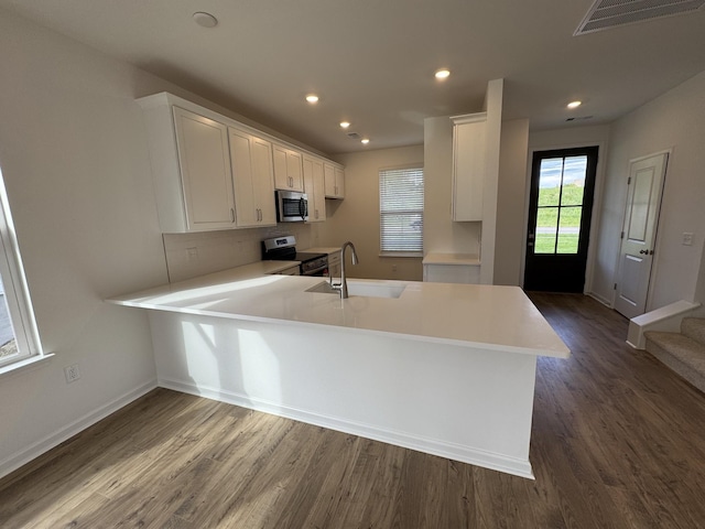410 Blair Rd, Smyrna, TN 37167 - kitchen with appliances with stainless steel finishes, a sink, a peninsula, dark wood-type flooring, and white cabinetry