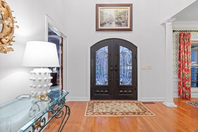 697 N Stewart Ln, Rising Fawn, GA 30738 - foyer entrance featuring wood finished floors, baseboards, decorative columns, arched walkways, and french doors