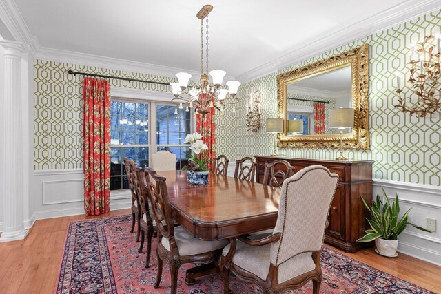 697 N Stewart Ln, Rising Fawn, GA 30738 - dining space with wallpapered walls, crown molding, a chandelier, ornate columns, and wood finished floors