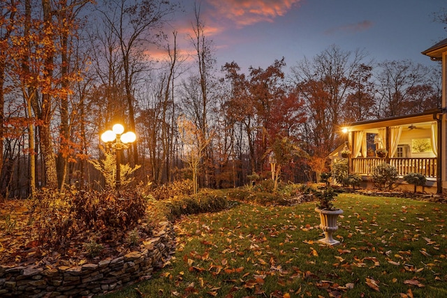 697 N Stewart Ln, Rising Fawn, GA 30738 - yard at dusk with ceiling fan, a lawn, and a porch