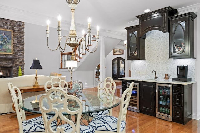 697 N Stewart Ln, Rising Fawn, GA 30738 - dining space featuring wine cooler, wet bar, light wood-type flooring, crown molding, and stairway