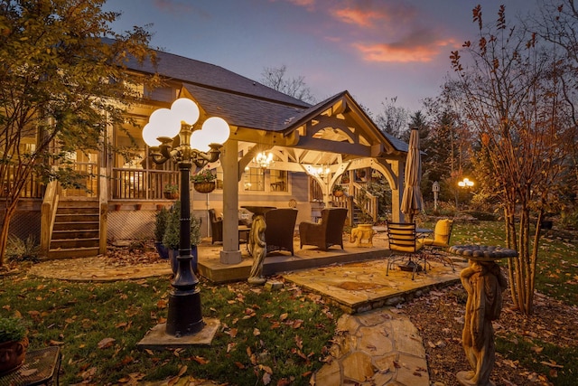697 N Stewart Ln, Rising Fawn, GA 30738 - patio terrace at dusk featuring stairway, a deck, and a patio area