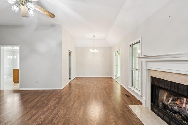 4348 Oakcrest Ln, Hermitage, TN 37076 - unfurnished living room featuring a chandelier, a fireplace with flush hearth, vaulted ceiling, and wood finished floors