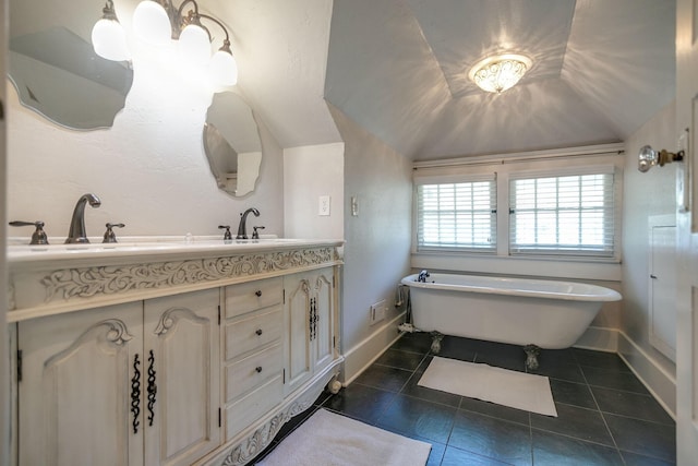 712 W Main St, Franklin, TN 37064 - bathroom with tile patterned floors, double vanity, a soaking tub, baseboards, and vaulted ceiling