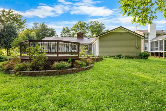 176 Kirby Dr, Clarksville, TN 37042 - back of house with a chimney, an attached garage, a deck, metal roof, and a lawn