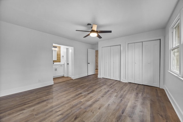 176 Kirby Dr, Clarksville, TN 37042 - unfurnished bedroom with two closets, baseboards, wood finished floors, ensuite bath, and a ceiling fan