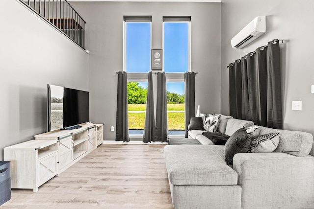 14 Lewter Rd, Taft, TN 38488 - living area with light wood-style flooring, a towering ceiling, an AC wall unit, and baseboards