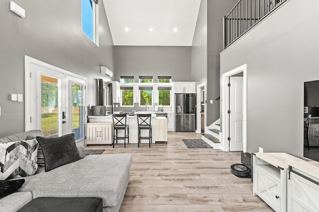 14 Lewter Rd, Taft, TN 38488 - living area with french doors, a towering ceiling, an AC wall unit, light wood finished floors, and stairs
