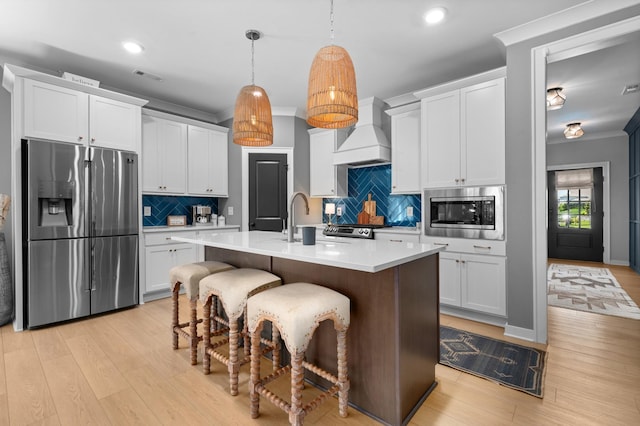 894 Plowson Rd, Mount Juliet, TN 37122 - kitchen with appliances with stainless steel finishes, custom exhaust hood, light wood-style floors, light countertops, and backsplash