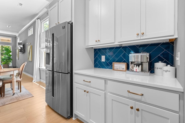 894 Plowson Rd, Mount Juliet, TN 37122 - kitchen with stainless steel fridge, backsplash, light wood-style floors, white cabinets, and light countertops