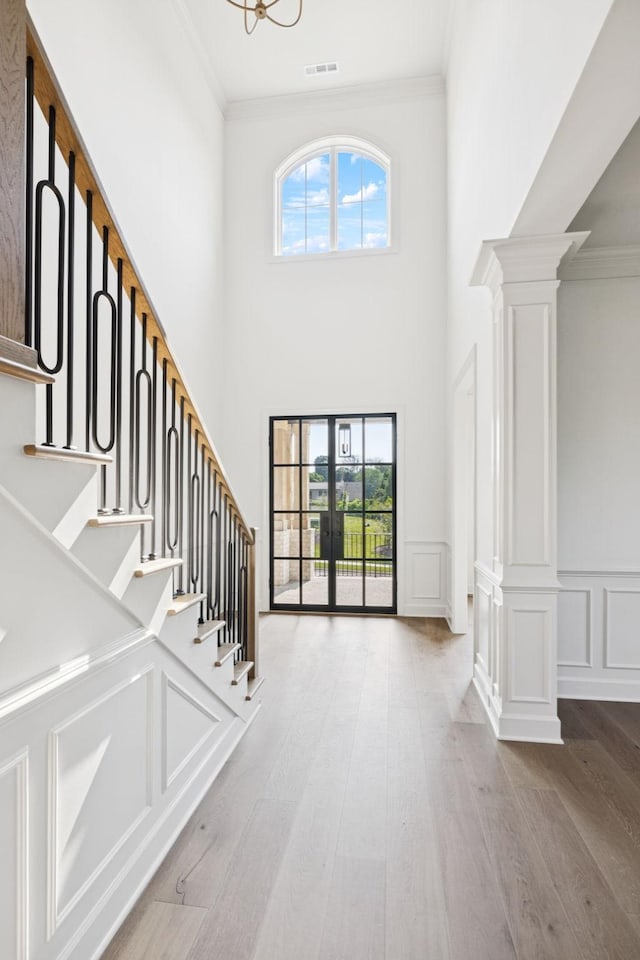 1001 Laguna Dr, Franklin, TN 37067 - foyer with ornate columns, healthy amount of natural light, wood finished floors, crown molding, and stairway