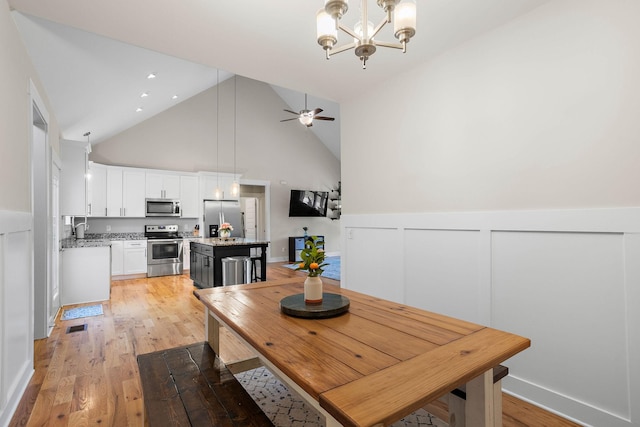 600 S Tunnel Rd, Gallatin, TN 37066 - dining space with light wood-type flooring, high vaulted ceiling, a wainscoted wall, a chandelier, and ceiling fan
