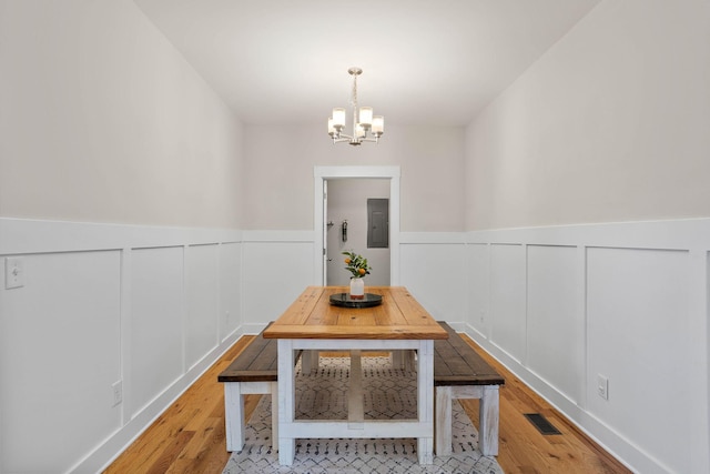 600 S Tunnel Rd, Gallatin, TN 37066 - dining room featuring electric panel, a chandelier, a decorative wall, light wood-style floors, and wainscoting