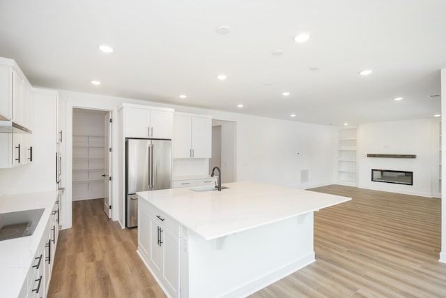 124 W Cassa Way, Mount Juliet, TN 37122 - kitchen with high quality fridge, a sink, an island with sink, white cabinets, and light wood finished floors