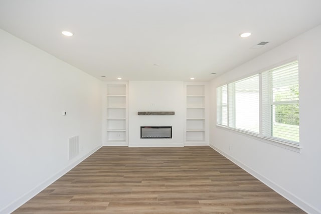 124 W Cassa Way, Mount Juliet, TN 37122 - unfurnished living room with a glass covered fireplace, built in shelves, light wood-style floors, and recessed lighting