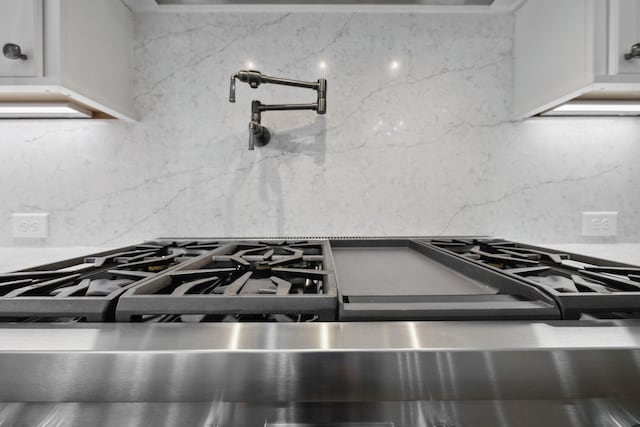 304 Berry Cir, Franklin, TN 37064 - detailed view of pot filler, gas stove, decorative backsplash, and white cabinets