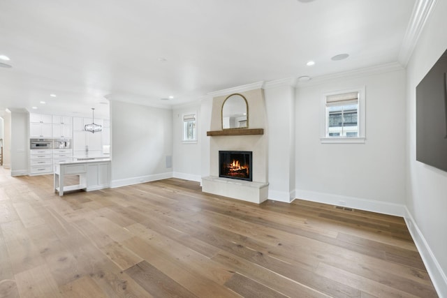 304 Berry Cir, Franklin, TN 37064 - unfurnished living room with plenty of natural light, a fireplace, light wood-style floors, ornamental molding, and baseboards
