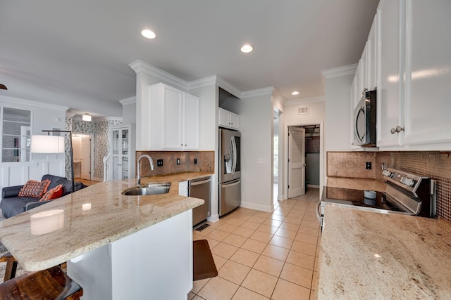 1119 Hudson Ln, Franklin, TN 37067 - kitchen featuring appliances with stainless steel finishes, a sink, a peninsula, decorative backsplash, and recessed lighting