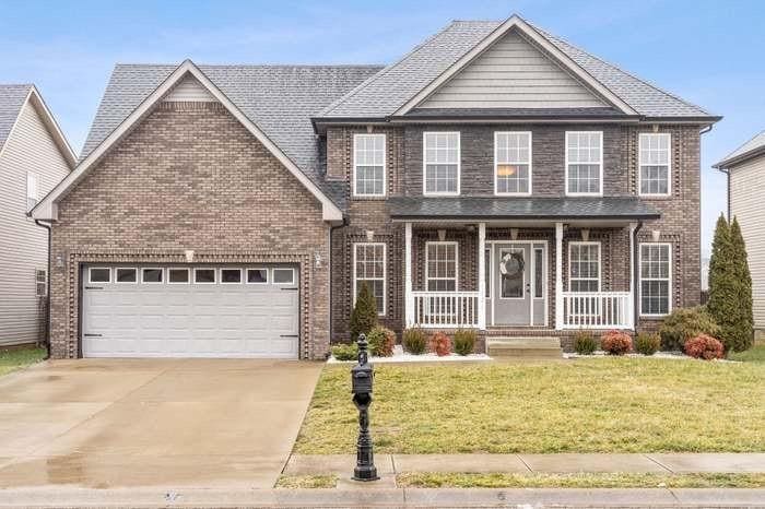 1121 Chinook Cir, Clarksville, TN 37042 - view of front of home featuring brick siding, a porch, driveway, and an attached garage